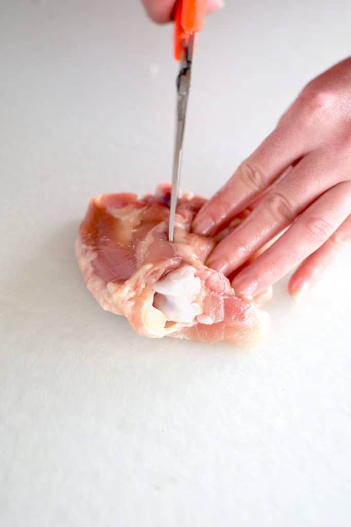 a chicken thigh being deboned