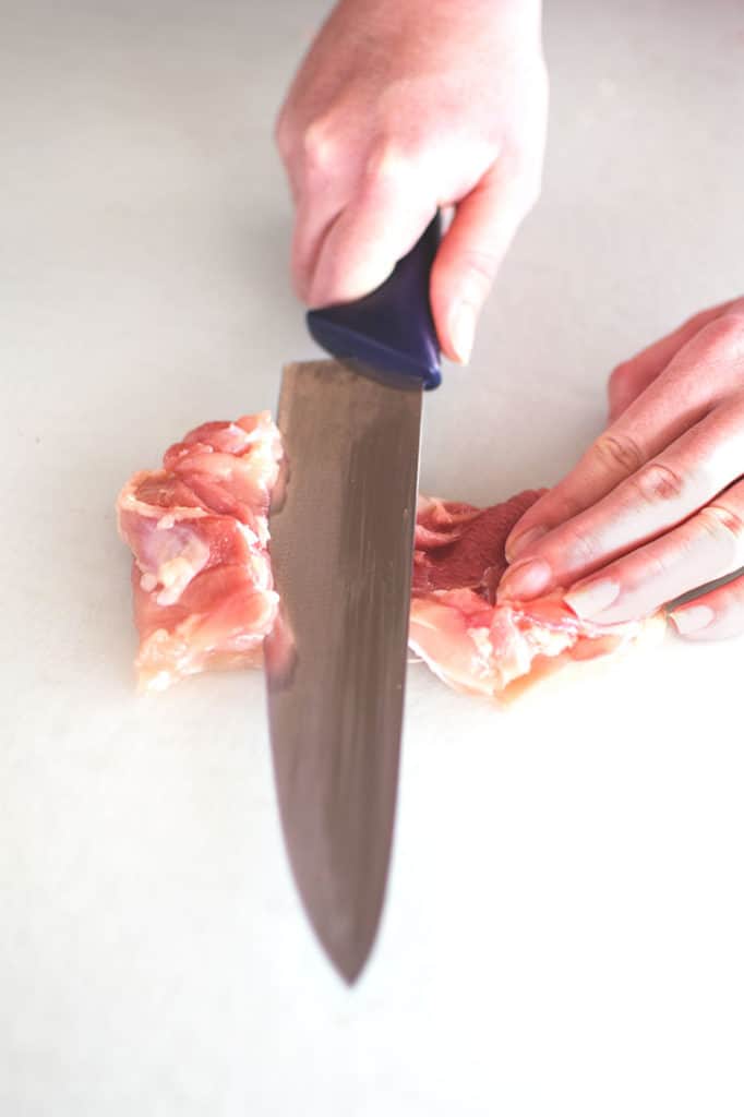 boness chicken thigh being cut