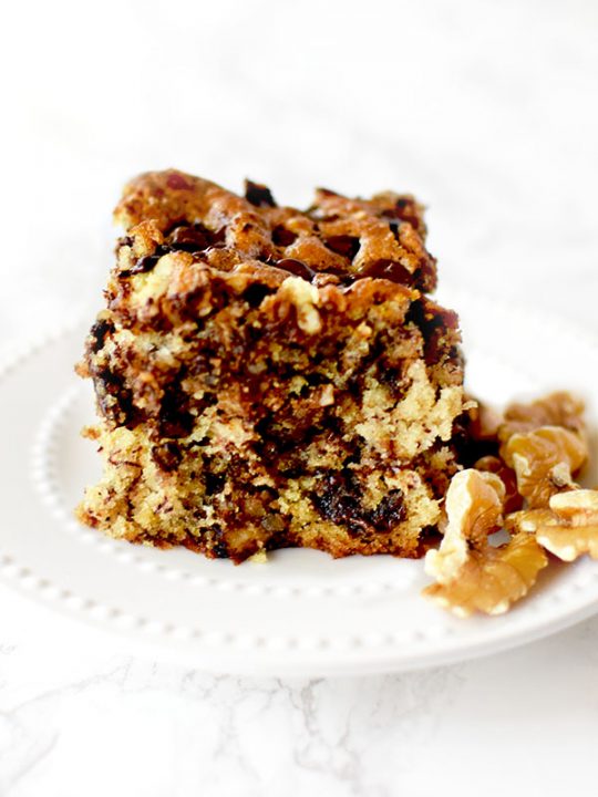 chocolate chip banana cake with nuts on a white plate