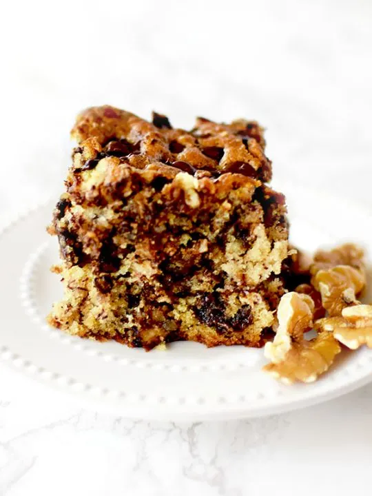 chocolate chip banana cake with nuts on a white plate