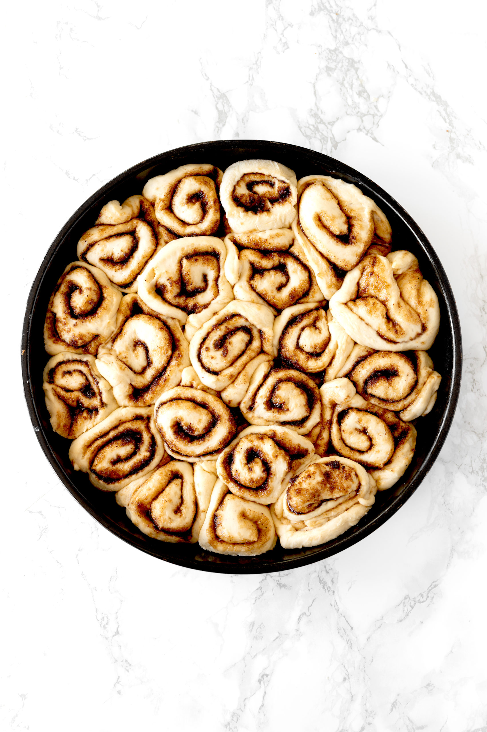 dairy free cinnamon rolls in a round baking pan