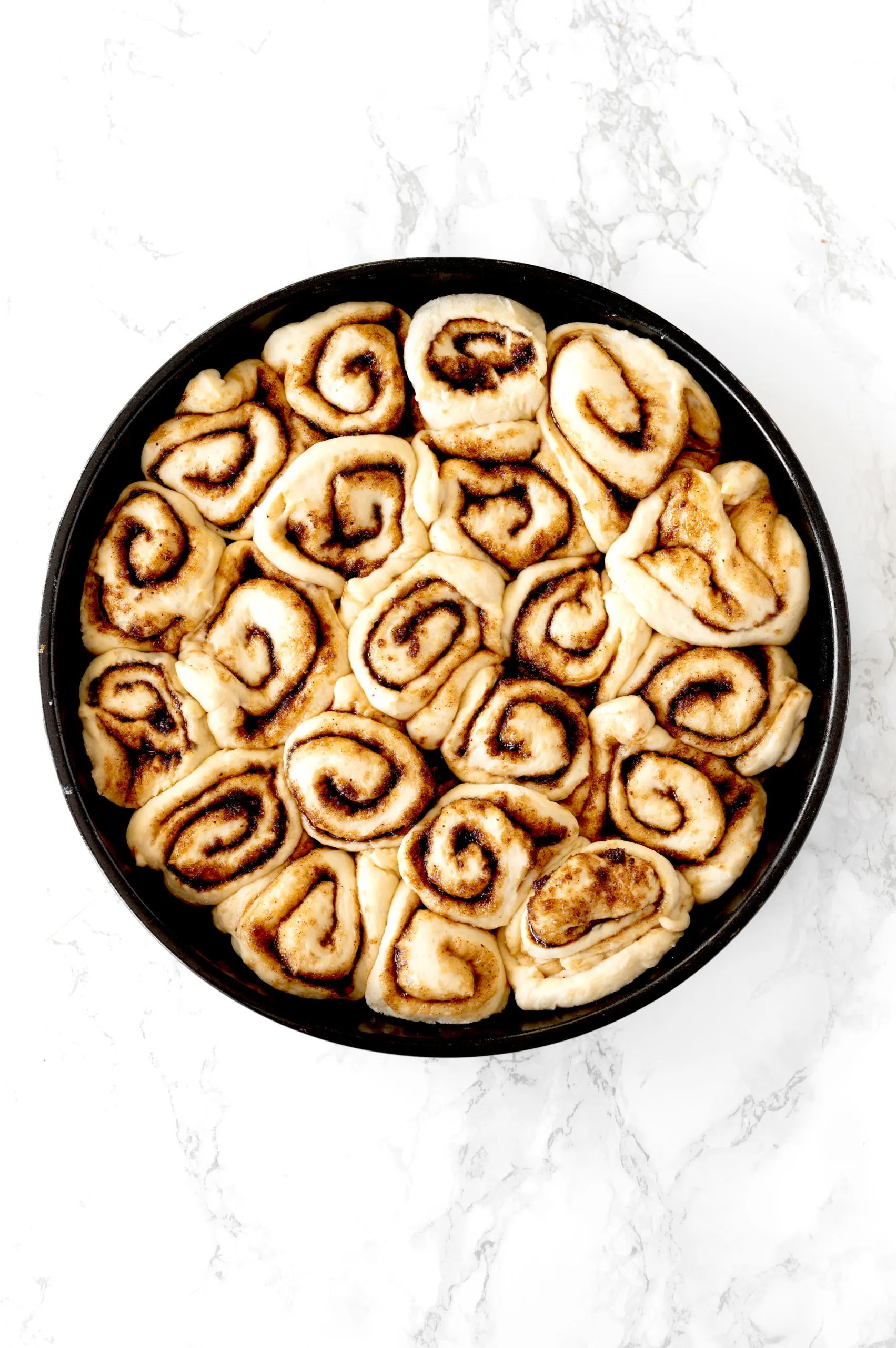 dairy free cinnamon rolls in a round baking pan
