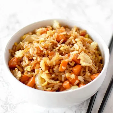 fried rice in a white bowl on a white marble counter