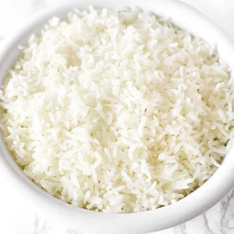 white rice in a white bowl on a marble counter