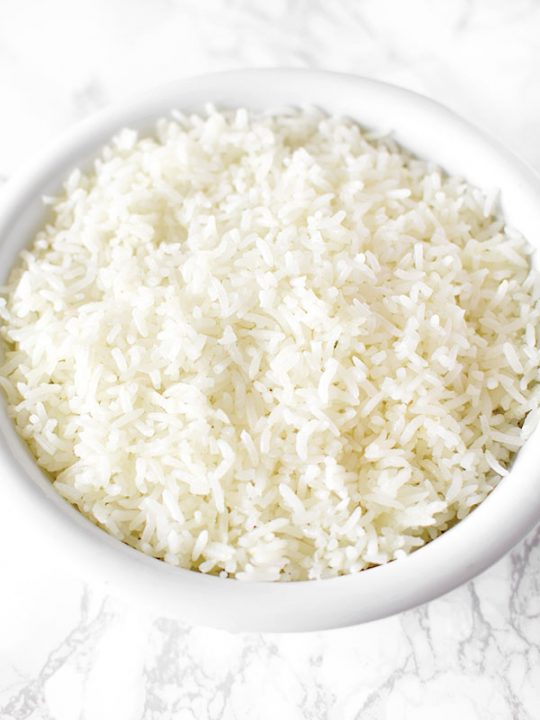 white rice in a white bowl on a marble counter