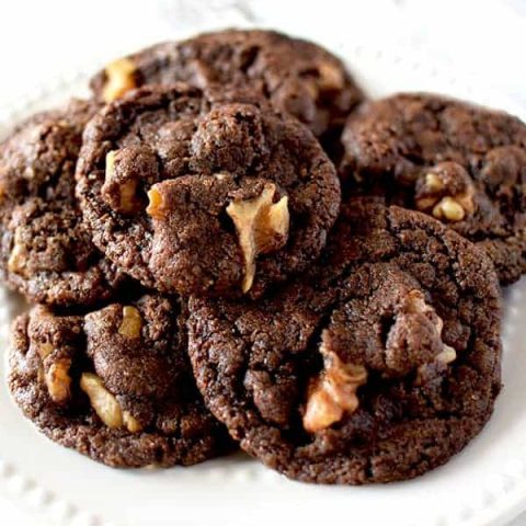 Chocolate cookies with walnuts on a white plate