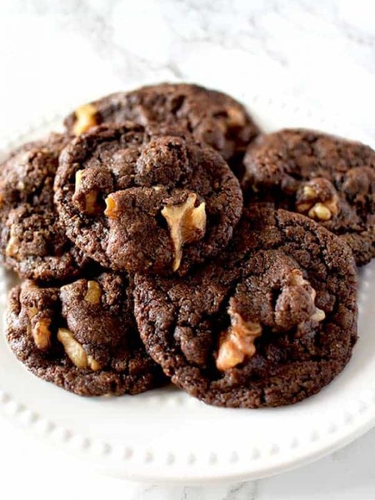 Chocolate cookies with walnuts on a white plate