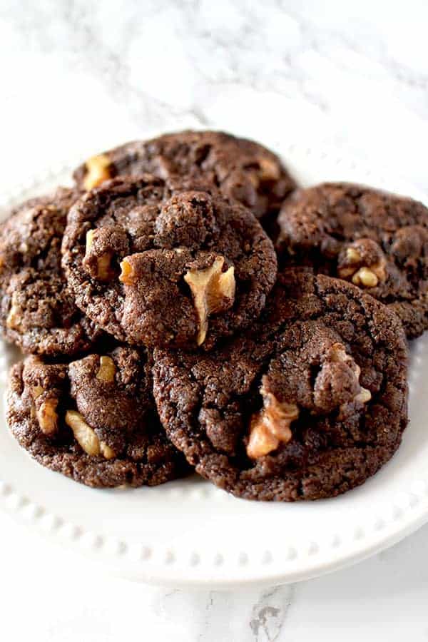 Chocolate cookies with walnuts on a white plate