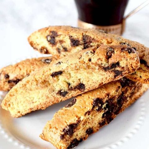 chocolate chip mandel briot on a plate next to black coffee