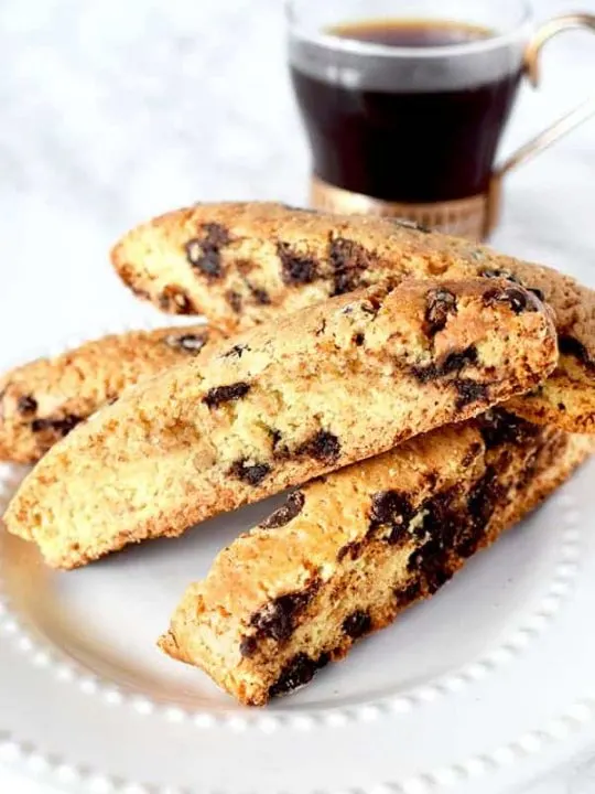 chocolate chip mandel briot on a plate next to black coffee