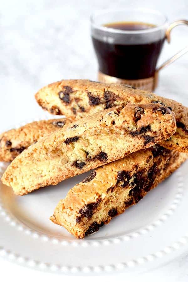 chocolate chip mandel briot on a plate next to black coffee