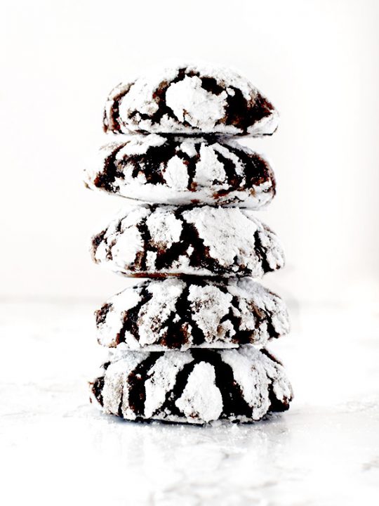 five chocolate crinkle cookies stacked