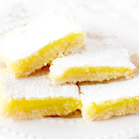 four dairy free lemon bars piled on a plate