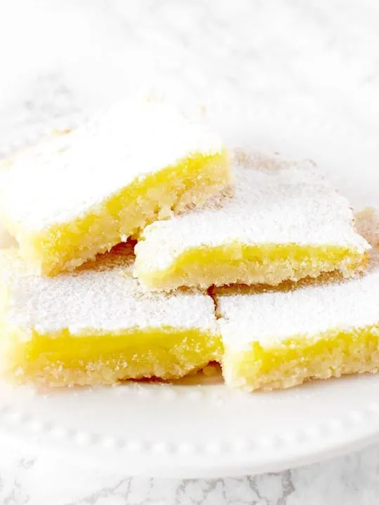 four dairy free lemon bars piled on a plate