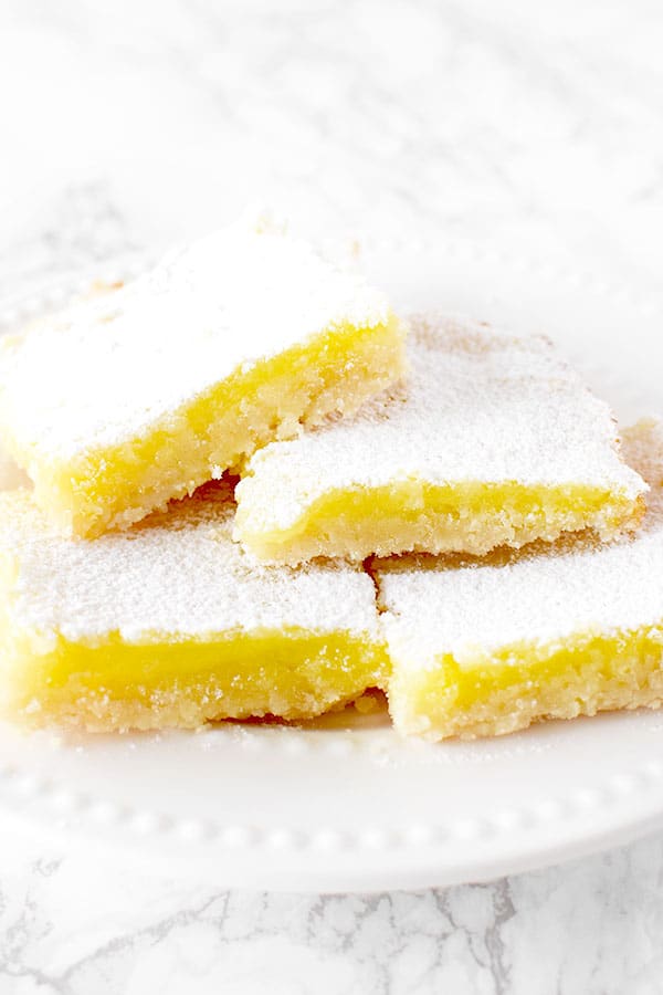 four dairy free lemon bars piled on a plate