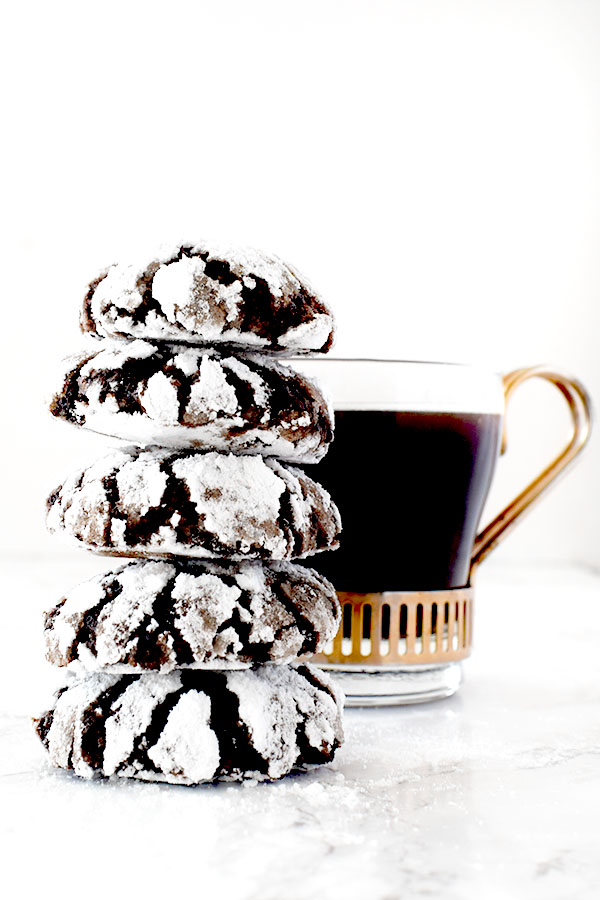 stack of mocha crinkle cookies near a cup of black coffee