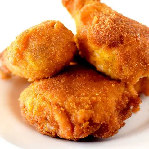 Pieces of fried cornflake chicken on a white plate