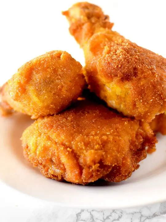 Pieces of fried cornflake chicken on a white plate