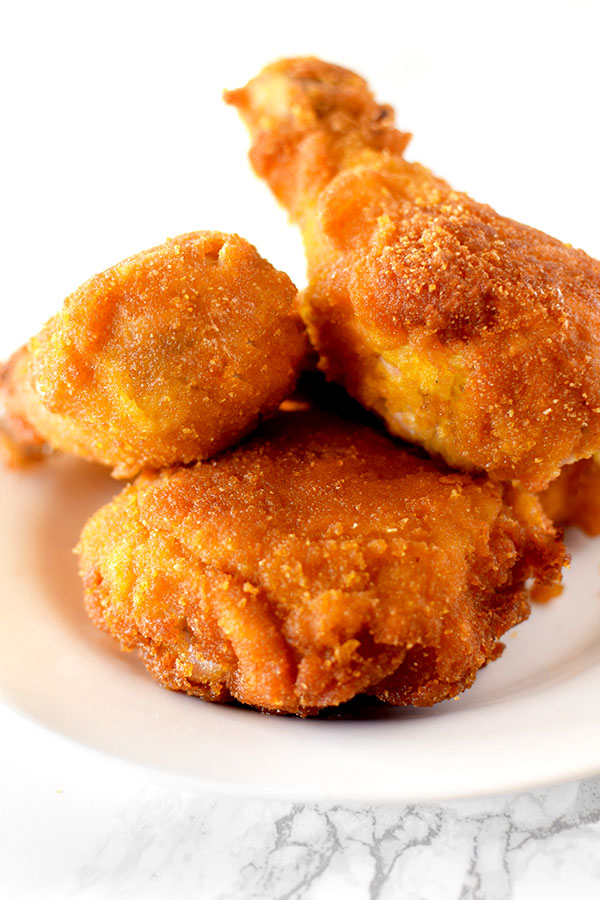 Pieces of fried cornflake chicken on a white plate