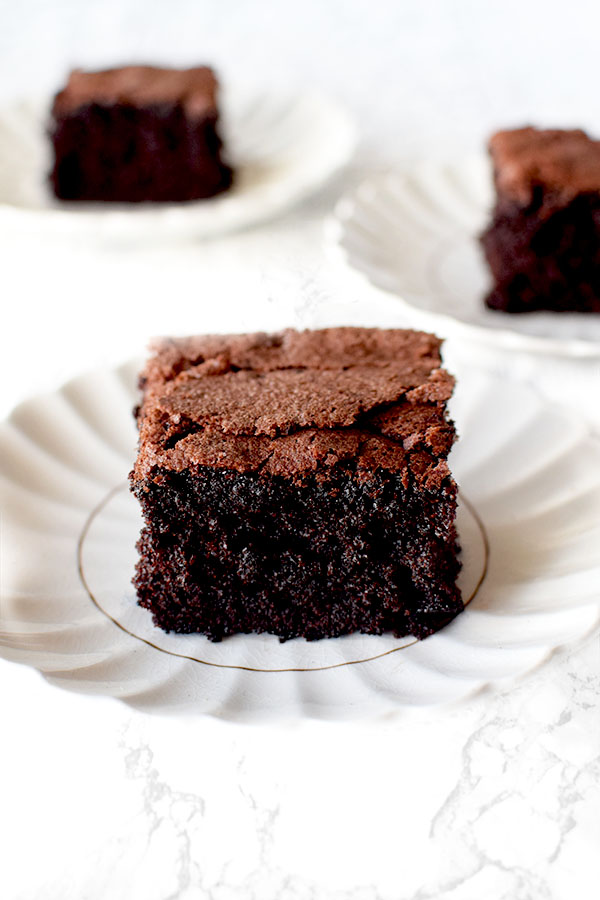 three slices of gluten free dairy free chocolate Cake on white plates