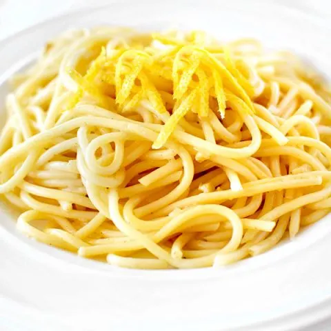 Spaghetti al Limone topped with lemon zest in a white bowl