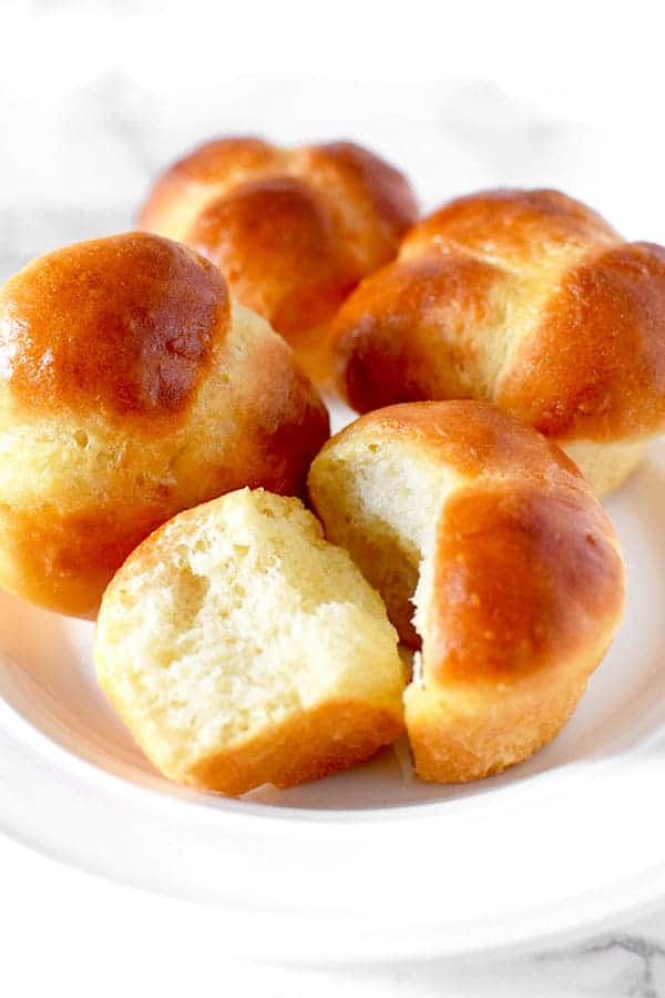 Four cloverleaf rolls on a white plate