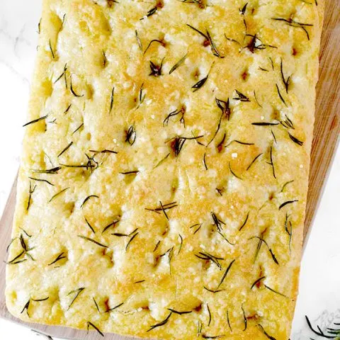 Rosemary and salt focaccia on a wooden cutting board