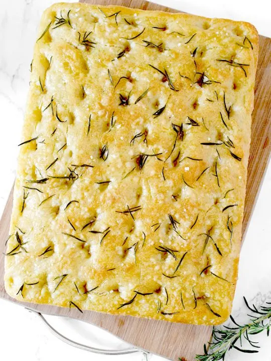 Rosemary and salt focaccia on a wooden cutting board