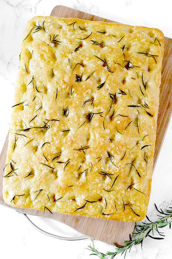 Rosemary and salt focaccia on a wooden cutting board