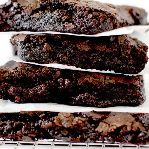 Fudge brownies stacked on a cooling rack