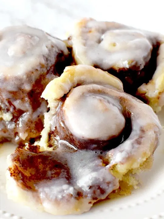 three overnight cinnamon rolls on a white plate