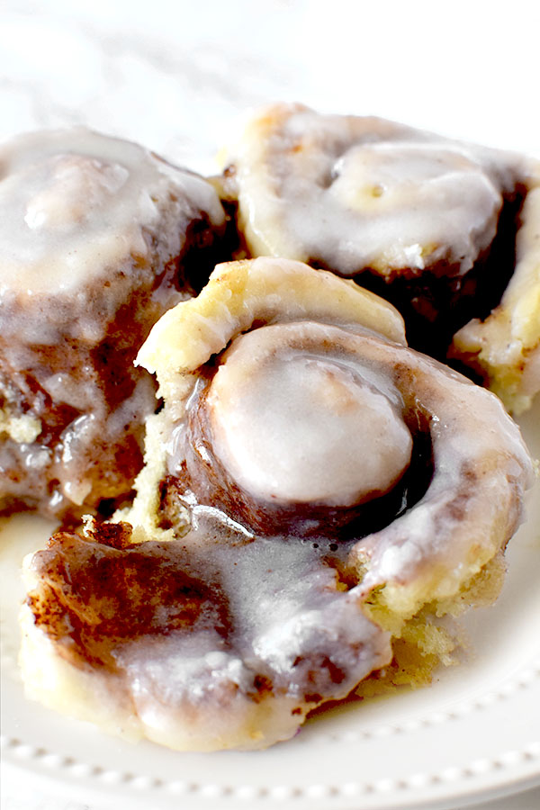 three overnight cinnamon rolls on a white plate