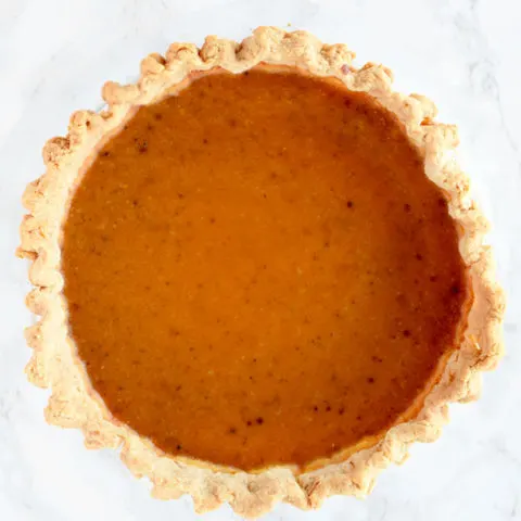 birds eye view of butternut squash pie on a white marble counter