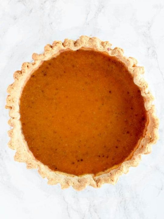 birds eye view of butternut squash pie on a white marble counter