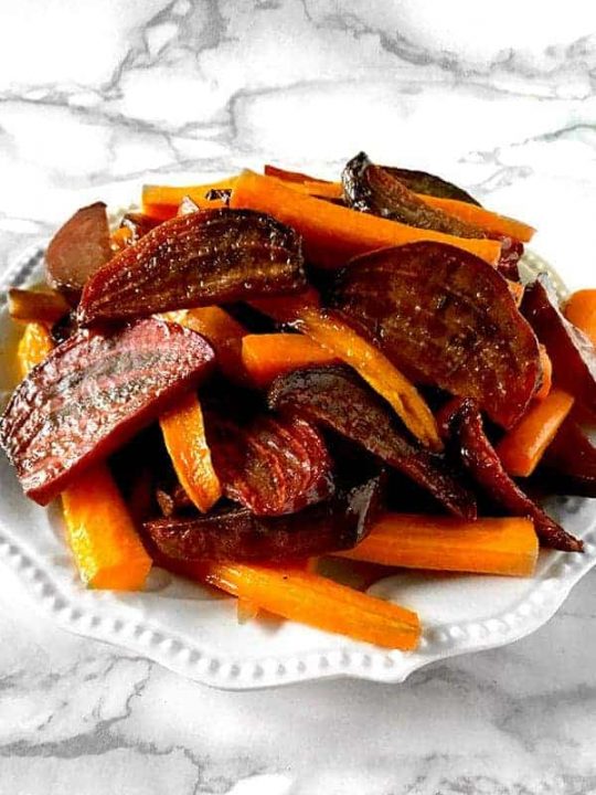 roasted beets and carrots on a white plate on a white marble counter
