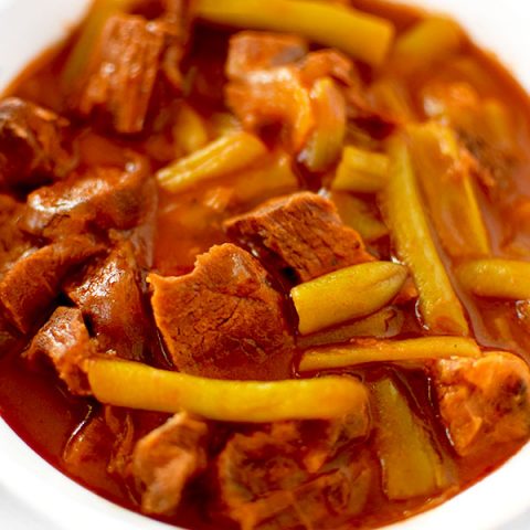 Israeli Beef and Green Beans in a white bowl on a white counter