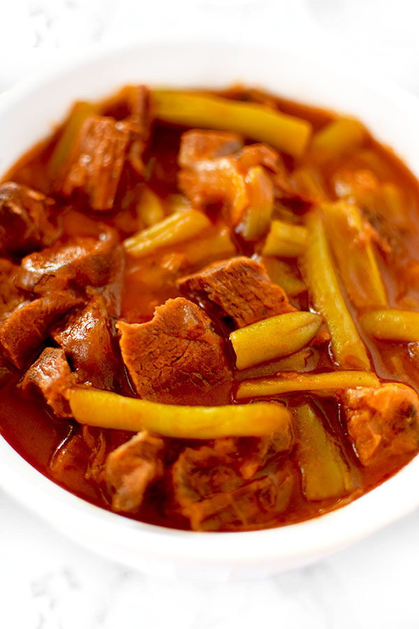 Israeli Beef and Green Beans in a white bowl on a white counter