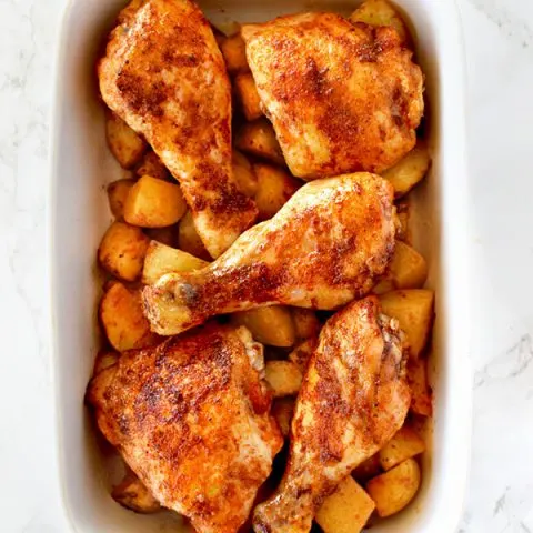 Roasted paprika chicken and potatoes in a white baking dish