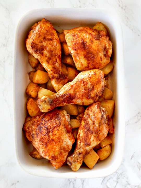 Roasted paprika chicken and potatoes in a white baking dish