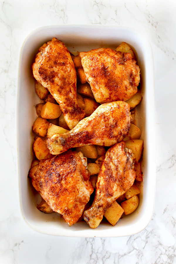 Roasted paprika chicken and potatoes in a white baking dish