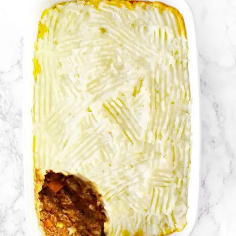 dairy free shepherd's pie or cottage pie in a white casserole dish on on a white marble counter