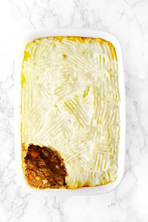 dairy free shepherd's pie or cottage pie in a white casserole dish on on a white marble counter