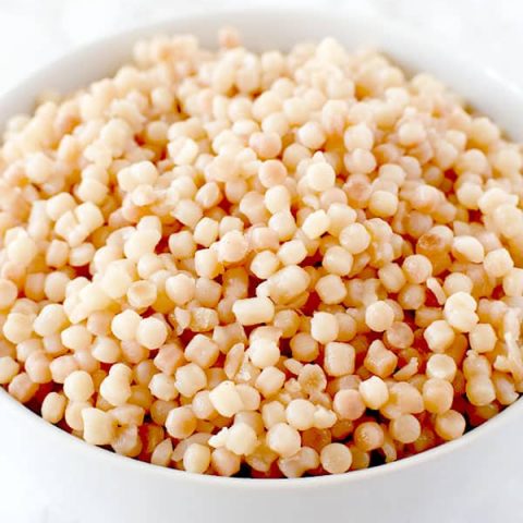 bowl of pearl couscous on a white marble counter