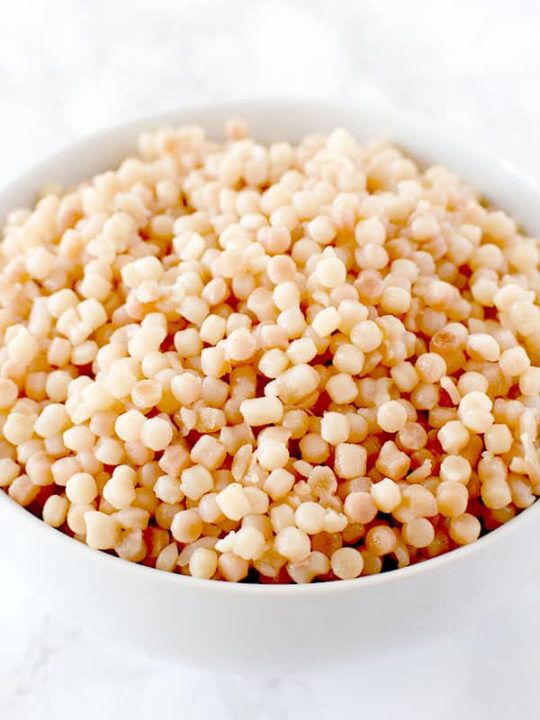 bowl of pearl couscous on a white marble counter