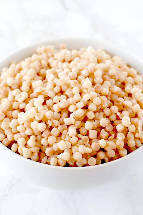 bowl of pearl couscous on a white marble counter