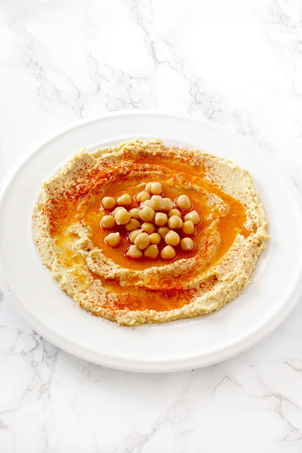 hummus in a plate on with oil, paprika, and chickpeas