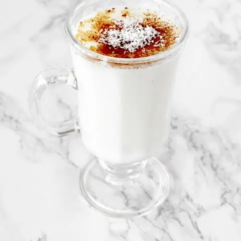 Cup of sachlav topped with cinnamon and coconut
