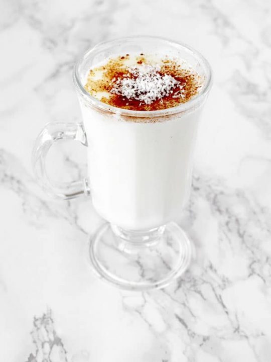 Cup of sachlav topped with cinnamon and coconut