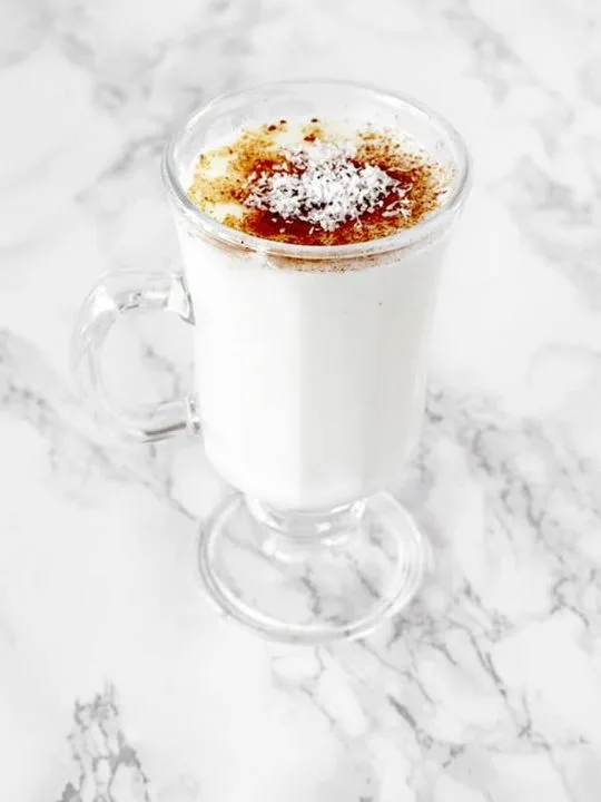 Cup of sachlav topped with cinnamon and coconut