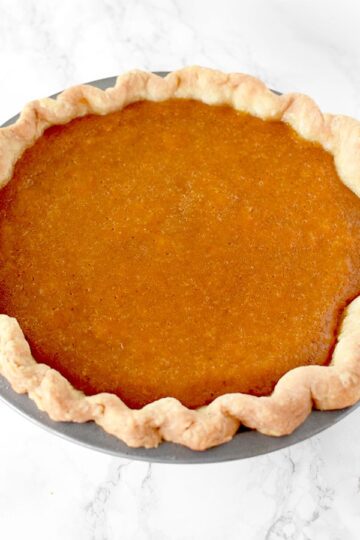 Dairy Free sweet potato pie in a homemade pie crust on a marble counter